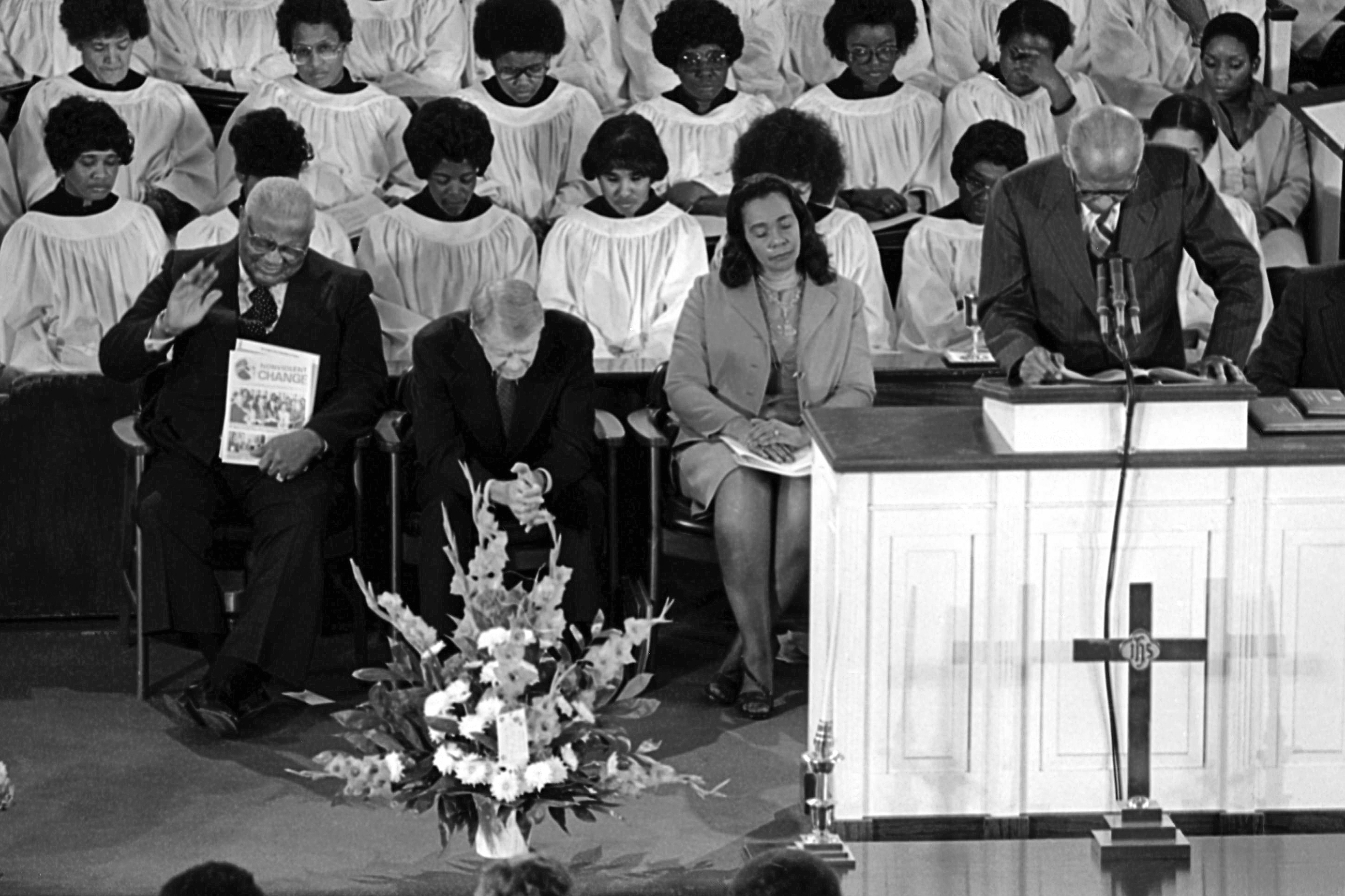 1979 年 1 月 14 日,老马丁·路德·金牧师(左)、卡特总统和小马丁·路德·金牧师的遗孀科丽塔·斯科特·金在亚特兰大埃比尼泽浸信会教堂举行的集会期间祈祷。