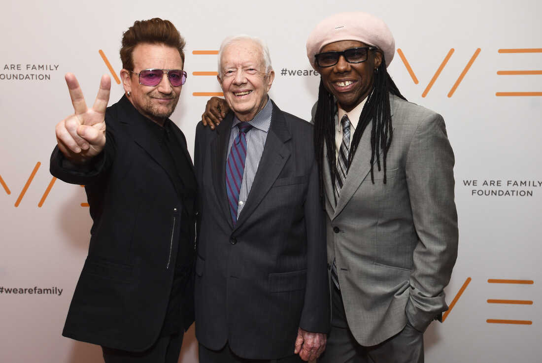 2016年4月29日：U2歌手波诺、前总统吉米·卡特和WAFF联合创始人尼罗·罗杰斯出席在纽约举行的We Are Family Foundation 2016年庆典晚会。