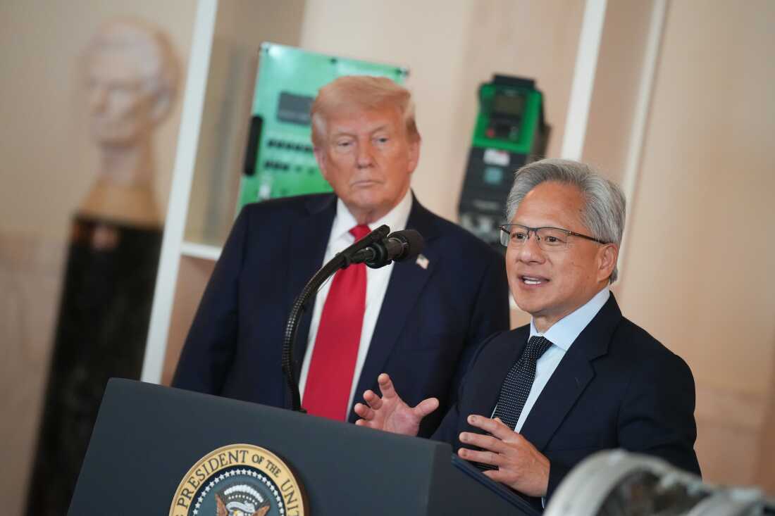 NVIDIA首席执行官詹森·黄（Jensen Huang）在2025年4月的白宫活动中从讲台的后面讲话。特朗普总统在他的身后，朝框架的左侧。