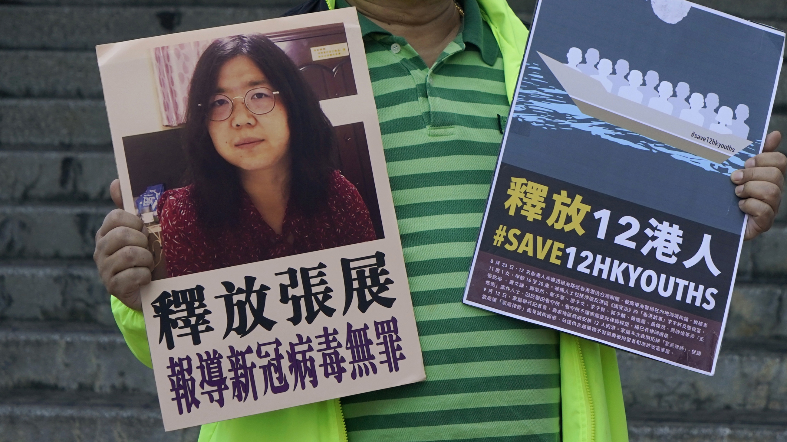 一名亲民主活动家于2020年12月28日在香港中国中央政府联络办公室外的中国公民记者张Zhan的图片张贴标语。