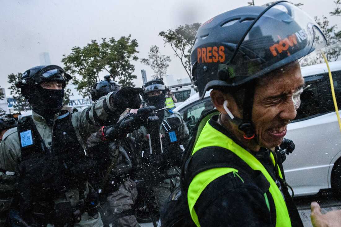 A journalist gets pepper-sprayed after a heated exchange with police during a rally in Hong Kong during demonstrations in support of the Uyghur minority in China, on Dec. 22, 2019. Hong Kong riot police broke up a solidarity rally for China's Uighurs on December 22 -- with one officer drawing a pistol -- as the city's pro-democracy movement likened their plight to that of the oppressed Muslim minority. （Anthony Wallace / AFP的照片）（Anthony Wallace / AFP通过Getty Images摄影）