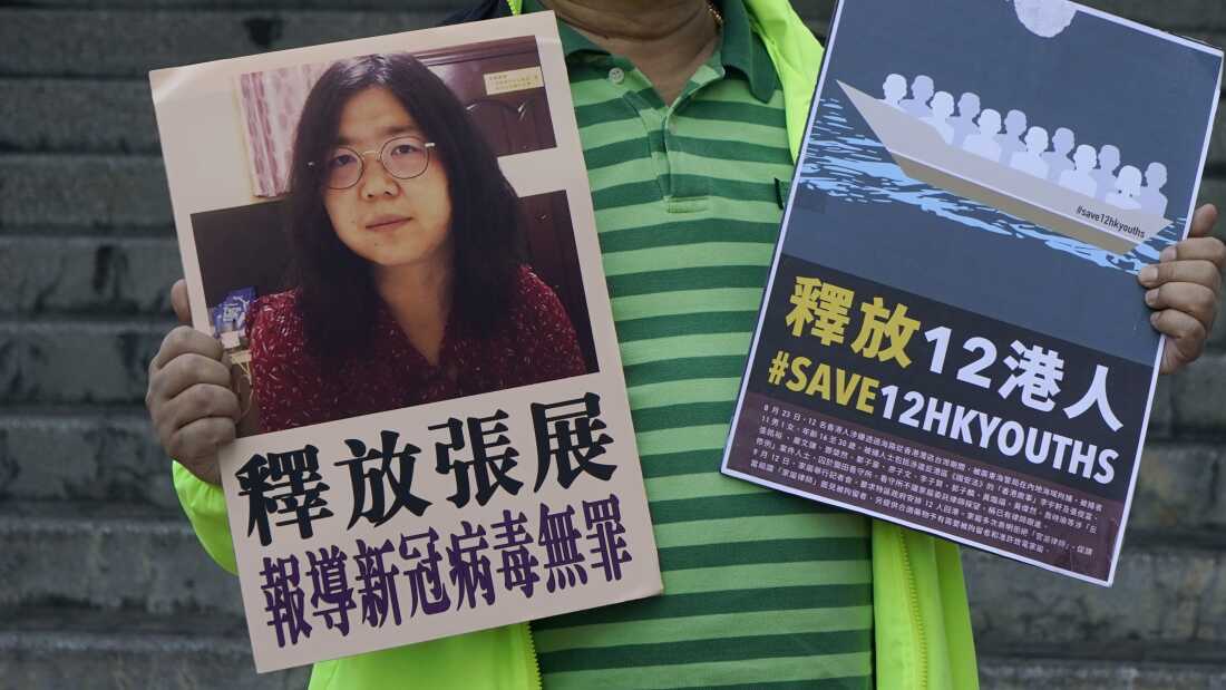 一名亲民主活动家于2020年12月28日在香港中国中央政府联络办公室外的中国公民记者张Zhan的图片张贴标语。