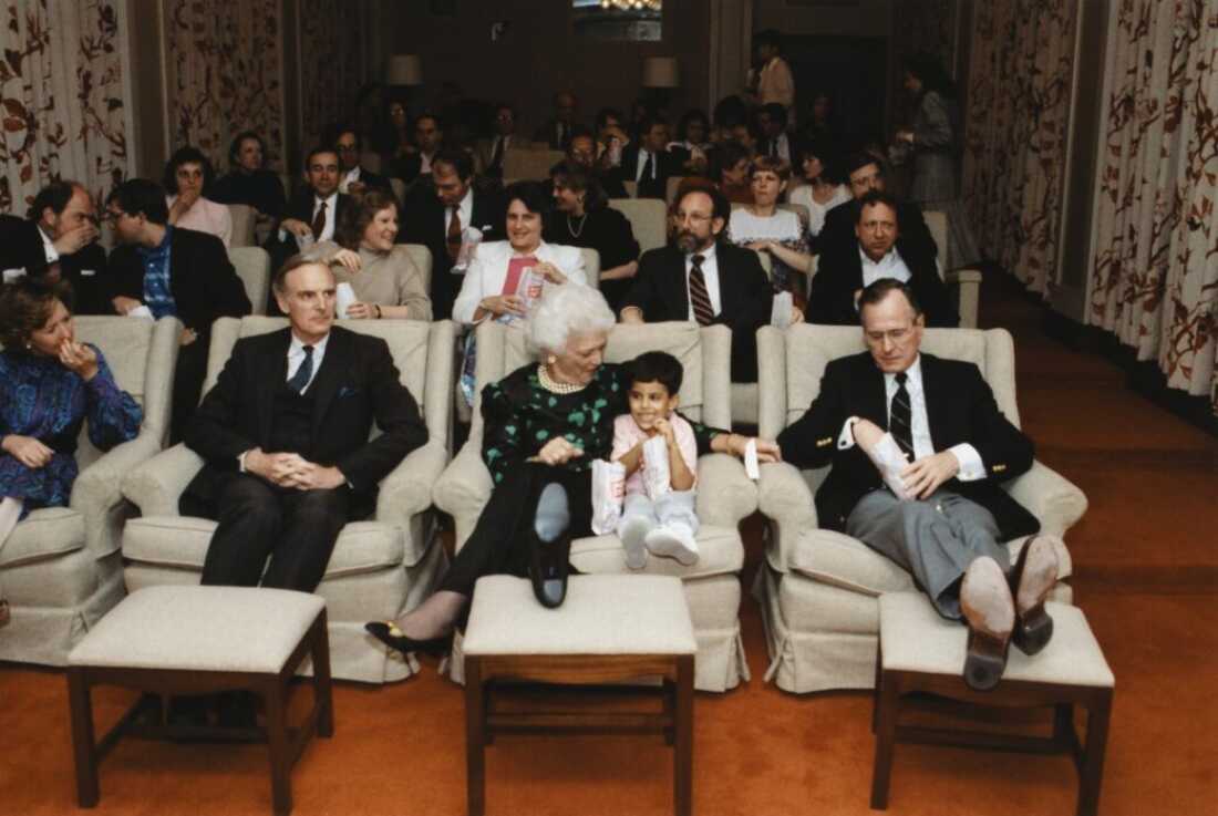 1989 年 4 月 14 日：乔治·布什总统和第一夫人芭芭拉·布什在白宫电影院举办放映会。布什夫人与她的孙子杰比·布什坐在一起。