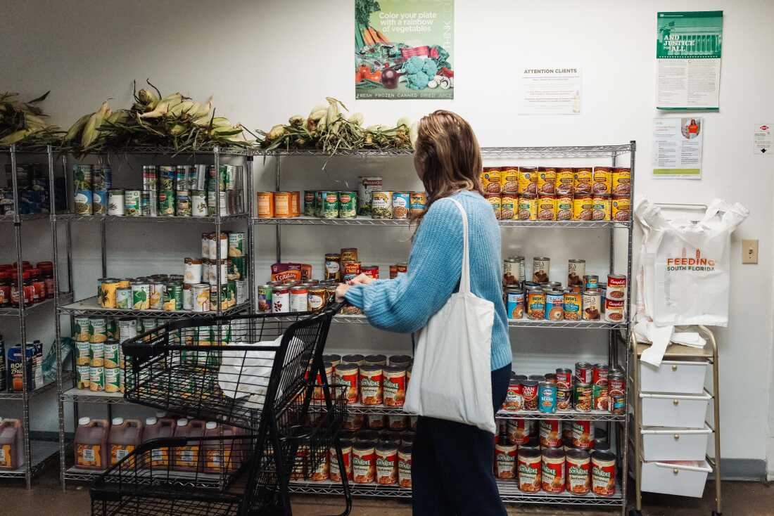 2025 年 10 月 31 日星期五，美国佛罗里达州彭布罗克公园，一名居民在 Feeding South Florida 的食品储藏室里浏览捐赠的食品。
