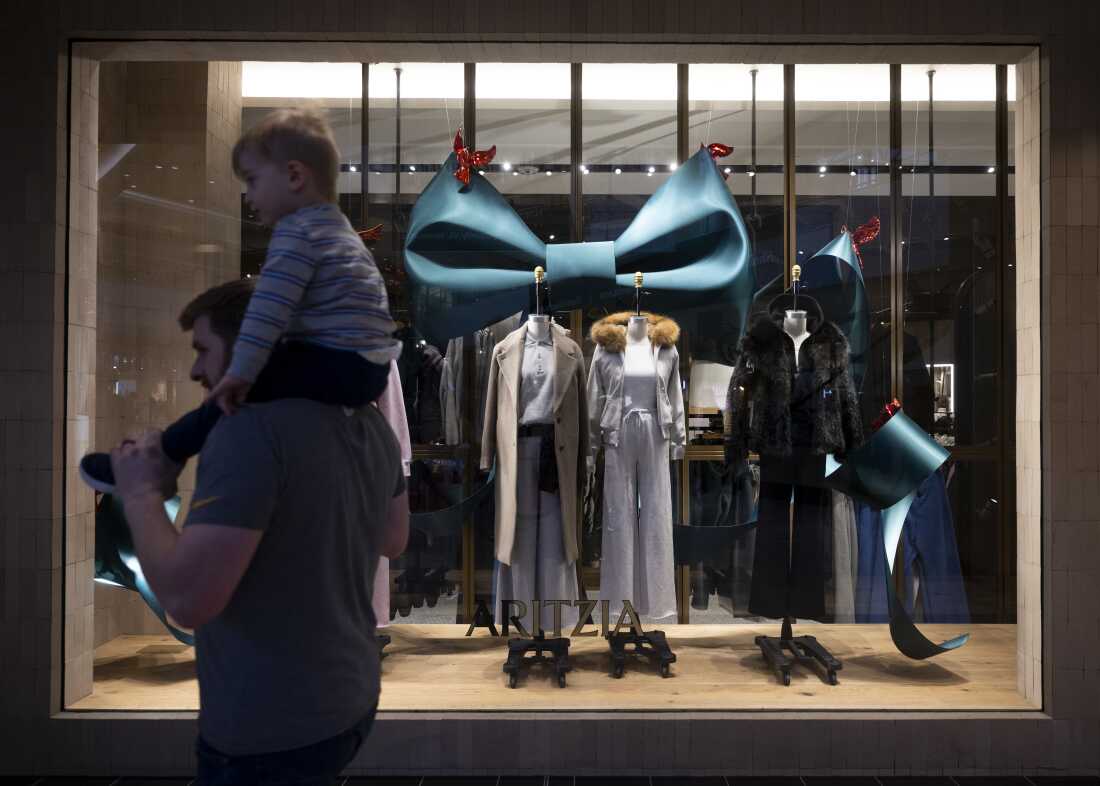 购物者走过罗斯公园购物中心 Aritzia 商店内陈列的服装。