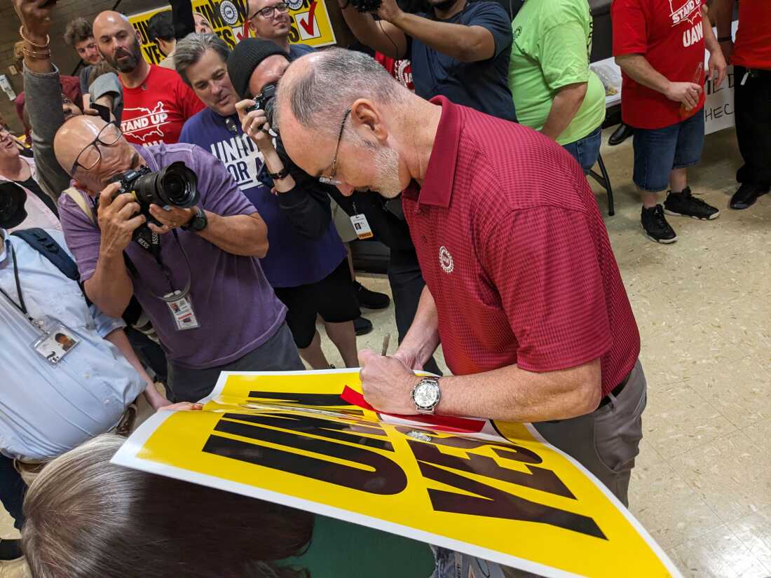 UAW 主席 Shawn Fain 签署 "联盟 是" 2024 年 4 月 19 日，工人投票加入 UAW 后，在田纳西州查塔努加举行的观看派对上签名