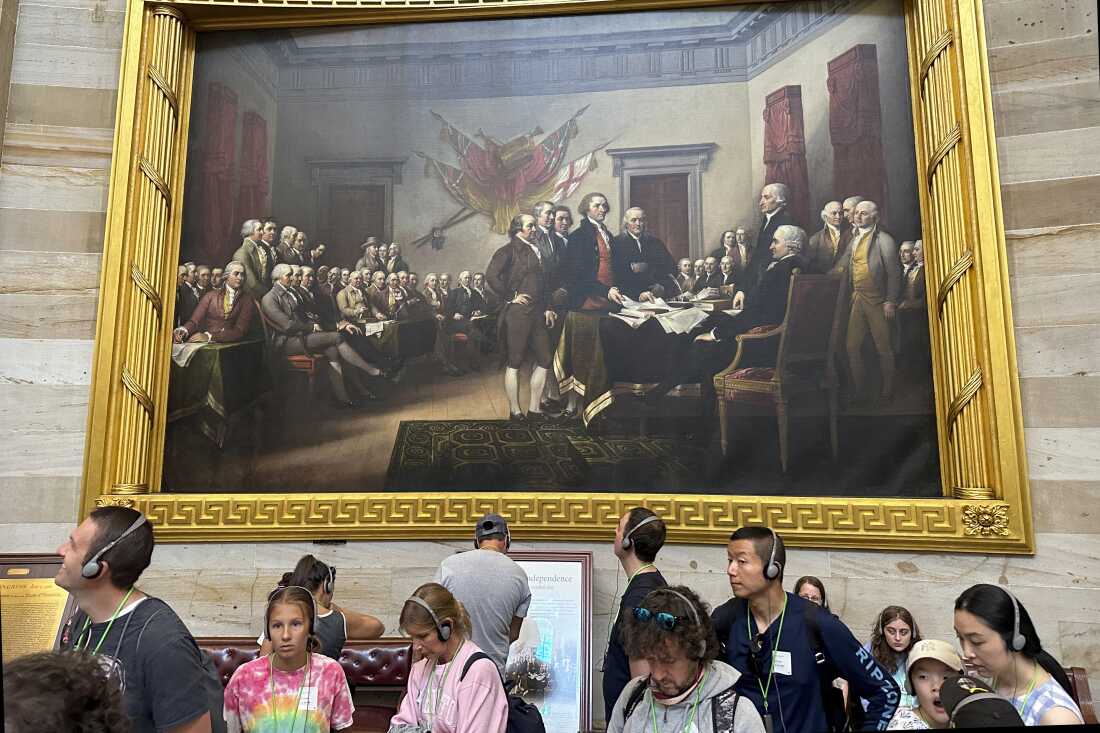 参观美国国会大厦的游客出现在约翰·特朗布尔 (John Trumbull) 具有传奇色彩的画作下，画作描绘了《独立宣言》提交给第二届大陆会议的那一刻。